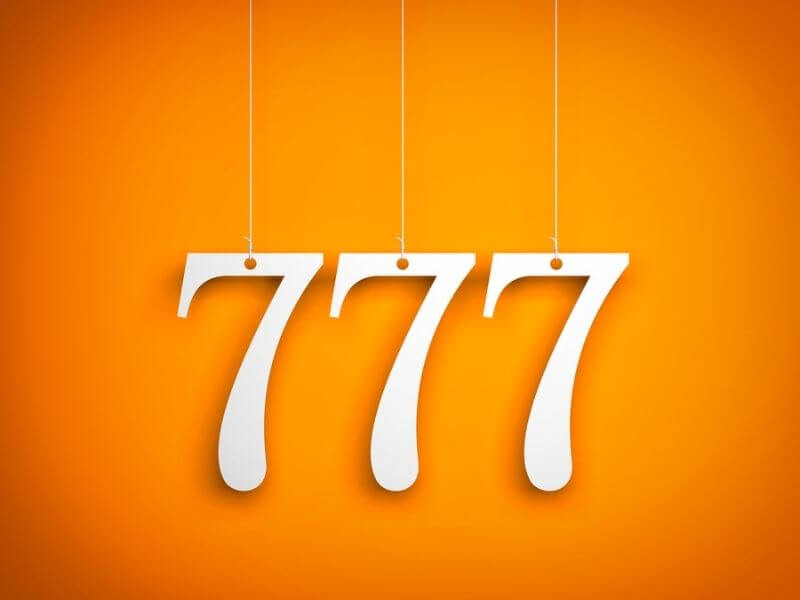 777 numbers hanging against an orange background.